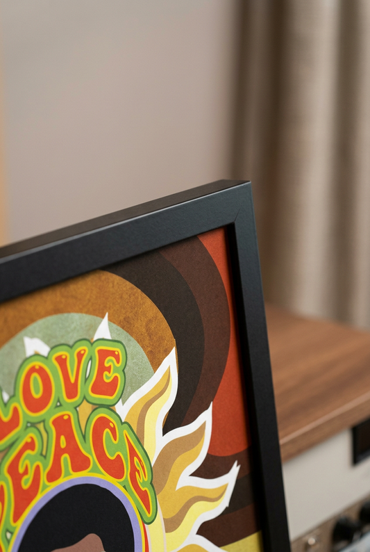 Close-up of the black frame corner and colorful LOVE PEACE and HAIR GREASE poster artwork.